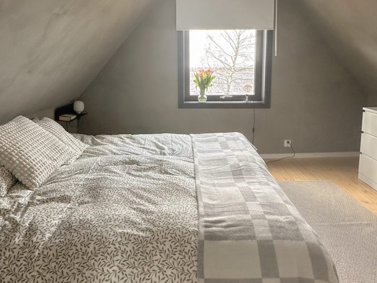 Gemütliches Schlafzimmer mit zwei Einzelbetten und einem Fenster, hell und skandinavisch eingerichtet.